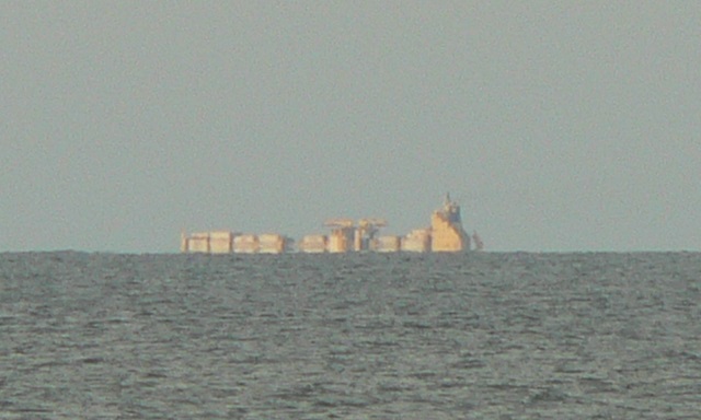 A cargo ship clearly over the horizon