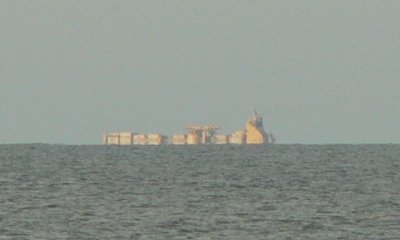 A cargo ship clearly over the horizon